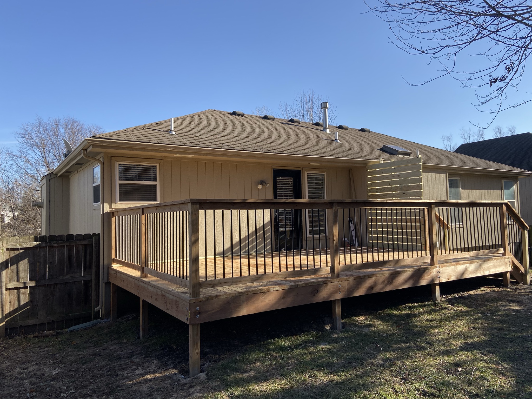 New cedar back deck with iron balusters and slatted privacy screen