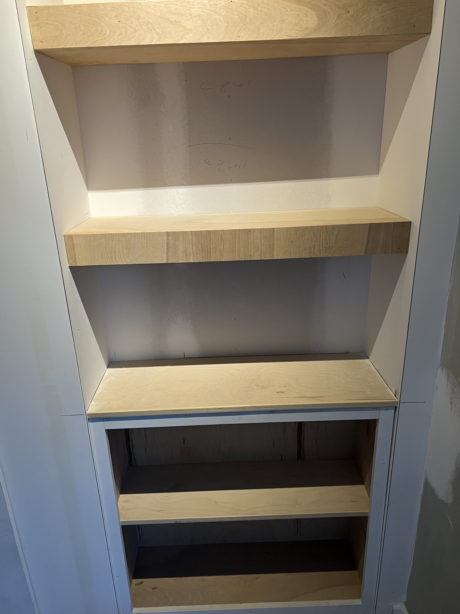 Built-in shelves under construction with primer and blocking visible